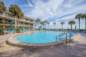 ein großer Pool mit Palmen und ein Hotel in der Unterkunft Ocean House 311 in Cedar Landing