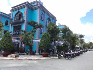 富國的住宿－Cam Hotel Phu Quoc，一排摩托车停在蓝色建筑前面