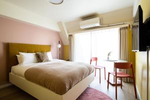 a bedroom with a bed and a desk and a window at Section L Hamamatsucho in Tokyo