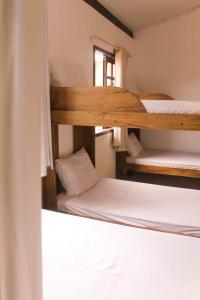 two bunk beds in a room with a window at Tiwá Hostel - antigo DaSanta - CENTRO in Arraial d'Ajuda