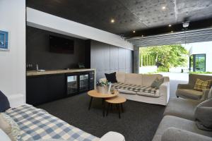 uma sala de estar com dois sofás e uma mesa em Bridle Path Retreat - Christchurch Holiday Homes em Christchurch