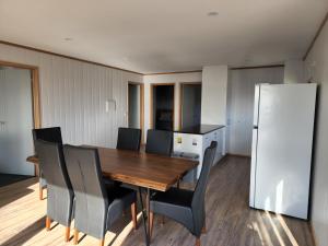 a dining room with a table and chairs and a refrigerator at Mount Rumney Escapes - 3 Seaview Wombat House in Mount Rumney