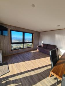 Mount Rumney Escapes - 3 Seaview Wombat House في Mount Rumney: غرفة معيشة مع أريكة وطاولة