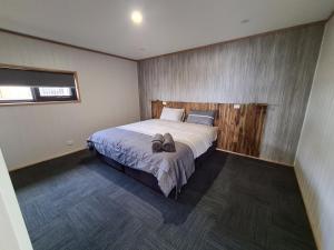 a bedroom with a bed with a pair of shoes on it at Mount Rumney Escapes - 3 Seaview Wombat House in Mount Rumney