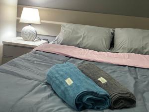 uma cama com duas toalhas e um candeeiro em Flat aconchegante próximo a Pelinca em Campos dos Goytacazes