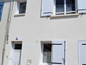 ein weißes Gebäude mit weißen Türen und Fenstern in der Unterkunft Maison La Tranche-sur-Mer, 2 pièces, 4 personnes - FR-1-22-256 in La Tranche-sur-Mer