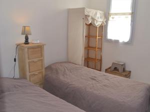 a bedroom with two beds and a dresser and a window at Maison proche plage et commerces à La Tranche-sur-Mer - FR-1-22-256 in La Tranche-sur-Mer