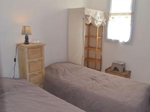 1 Schlafzimmer mit 2 Betten, einer Kommode und einem Fenster in der Unterkunft Maison La Tranche-sur-Mer, 2 pièces, 4 personnes - FR-1-22-256 in La Tranche-sur-Mer