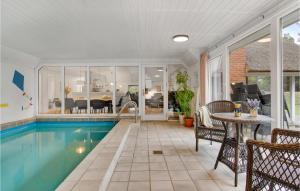 ブラーバンドにあるGorgeous Home In Blvand With Indoor Swimming Poolのリビングルーム(テーブル、椅子付)のスイミングプールを利用できます。
