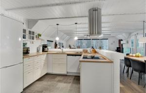 ブラーバンドにあるGorgeous Home In Blvand With Indoor Swimming Poolの白いキャビネットと電化製品付きの広い白いキッチン