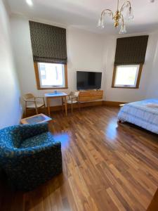 una camera con letto, divano e TV di RIALTO SUITES Fremantle a Fremantle