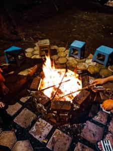 eine Feuerstelle mit Stühlen und Stühlen drum herum in der Unterkunft Saung Arjuna Syandana Resort in Ciwidey