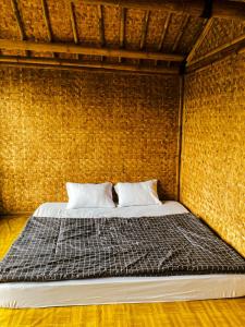 a bed in a room with a brick wall at Saung Arjuna Syandana Resort in Ciwidey