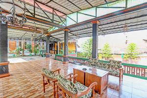Großes Zimmer mit Stühlen und einem Holztisch in der Unterkunft Capital O 91650 Hotel Pratama in Kolaka