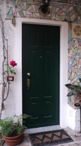 a green door on the side of a house at B&B Mirna in Vaprio dʼAdda