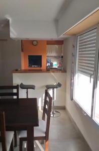 cocina y comedor con mesa y sillas en Casa Agustín en Balneario Claromecó
