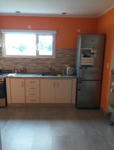 a kitchen with a stainless steel refrigerator and a window at Casa Agustín in Balneario Claromecó