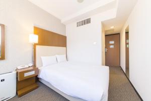 una camera d'albergo con letto e telefono di Hotel IL Cuore Namba ad Osaka