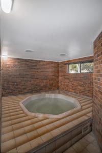 a jacuzzi tub in a brick wall at All Seasons Motel Armidale in Armidale