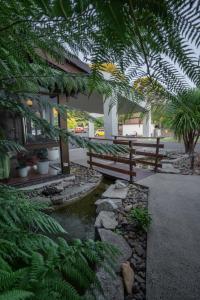 un puente sobre un arroyo en un patio con plantas en All Seasons Motel Armidale, en Armidale