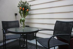 einen Tisch und Stühle mit einer Blumenvase auf der Terrasse in der Unterkunft B&B Keizers Canal in Amsterdam