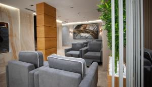 a waiting room with gray chairs and a wall at Doanesia Premium Hotel & Spa in Tirana