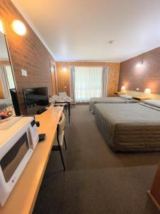 a hotel room with two beds and a television at Country Roads Motor Inn in Narrandera