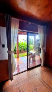 a room with a door open to a patio with a table at Cabañas Keuhenua in Hanga Roa