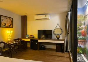 a room with a desk with a television and a table at My House Hotel - 350 Trần Khát Chân - by Bay Luxury in Hanoi