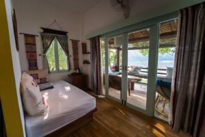 a bedroom with a bed and a view of a patio at Ock Pop Tok Mekong Villa in Luang Prabang