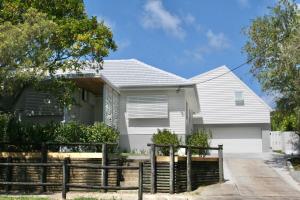 a white house with a fence in front of it at The Byron Bay Guesthouse in Byron Bay