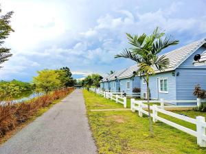 une maison bleue avec une clôture blanche à côté d'une route dans l'établissement The memory luxury resort, 