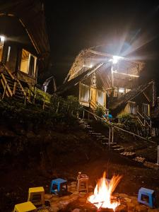 a campfire in front of a building at night at Villa Bima Syandana Resort in Ciwidey