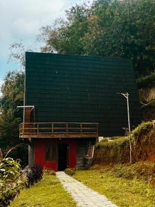 a red building with a black roof on a hill at Villa Bima Syandana Resort in Ciwidey