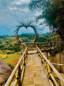 een houten brug met een hartvormige boog op de achtergrond bij Villa Bima Syandana Resort in Ciwidey