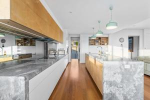 a kitchen with marble countertops and a large island at Daybreak at Currumbin in Gold Coast