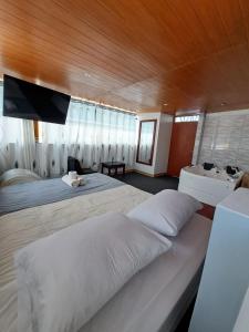 1 dormitorio grande con 2 camas y bañera en Hotel Alpamayo Guest House, en Huaraz