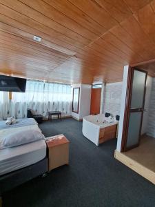 Una habitación con 2 camas y bañera y una habitación con en Hotel Alpamayo Guest House, en Huaraz