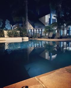 a swimming pool in front of a building at night at Nautilus Beach Apartment Merimbula in Merimbula