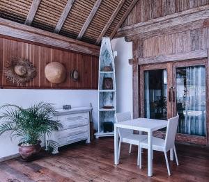 a dining room with a table and chairs and a desk at Akasia Villas in Gili Islands