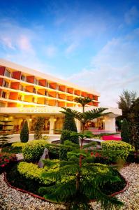 a hotel with a garden in front of a building at Wiang Inn Hotel in Chiang Rai