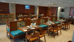 a dining room with wooden tables and chairs at Purple Beds by VITS Dwarkesh, Surat in Salabatpura