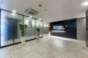 a hallway with potted plants in a building at Wall Hotel in Cheonan