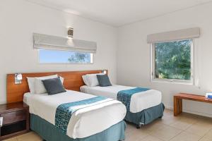 a hotel room with two beds and a window at Mantarays Ningaloo Beach Resort in Exmouth