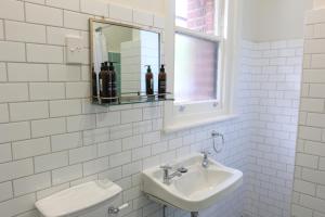 Alpine Hotel, Eat Drink Sleep في واربورتون: حمام مع حوض ومرحاض ومرآة