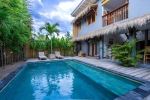 a villa with a swimming pool and a house at Akasia Villas in Gili Islands