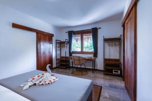 a bedroom with a bed with a swan on it at Akasia Villas in Gili Air