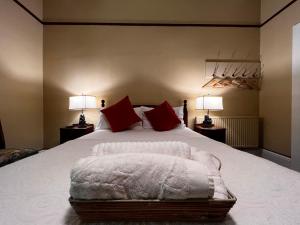 a bedroom with a bed with red pillows and two lamps at The Boutique Hotel Blue Mountains in Blackheath