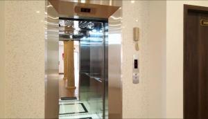 un ascensor de cristal en una habitación con columnas en Adal Motel en Kiến An