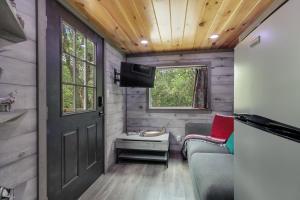 a tiny house with a door and a window at Stunning Modern Tiny Home with Grill in Fredericksburg